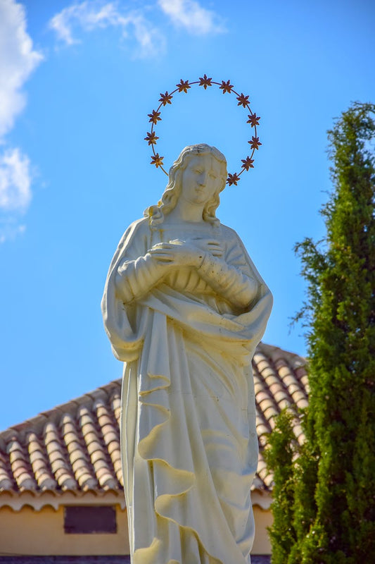Virgin Mary statue against blue sky - the Miraculous Medal story - Catholically