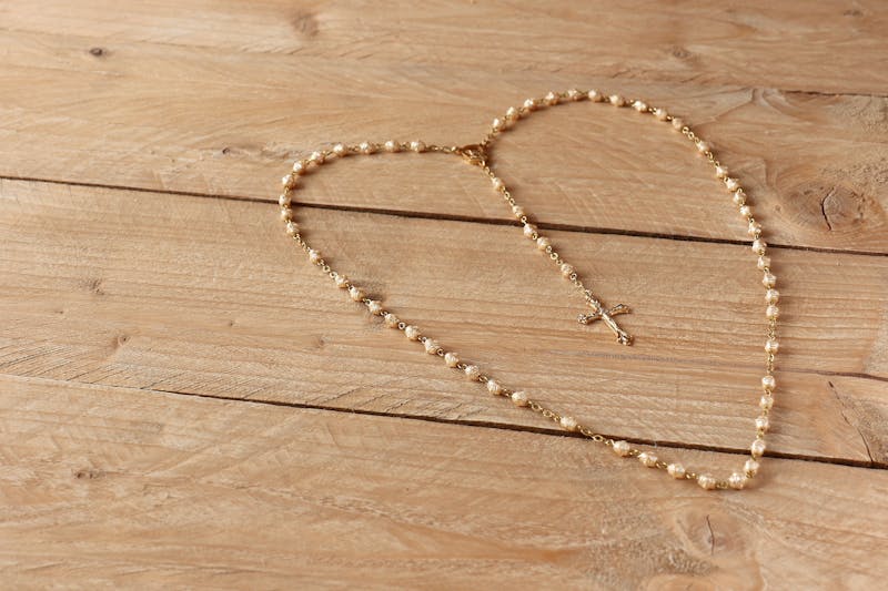Rosary blessed by Pope on wooden surface - Catholically