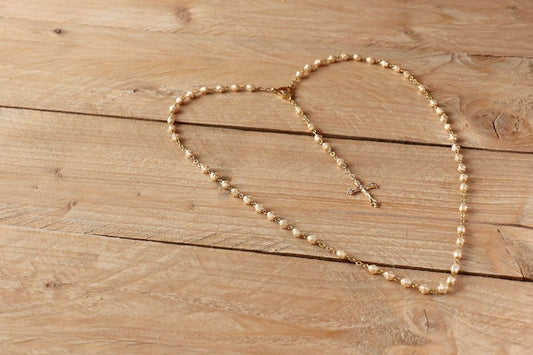 Rosary blessed by Pope on wooden surface - Catholically